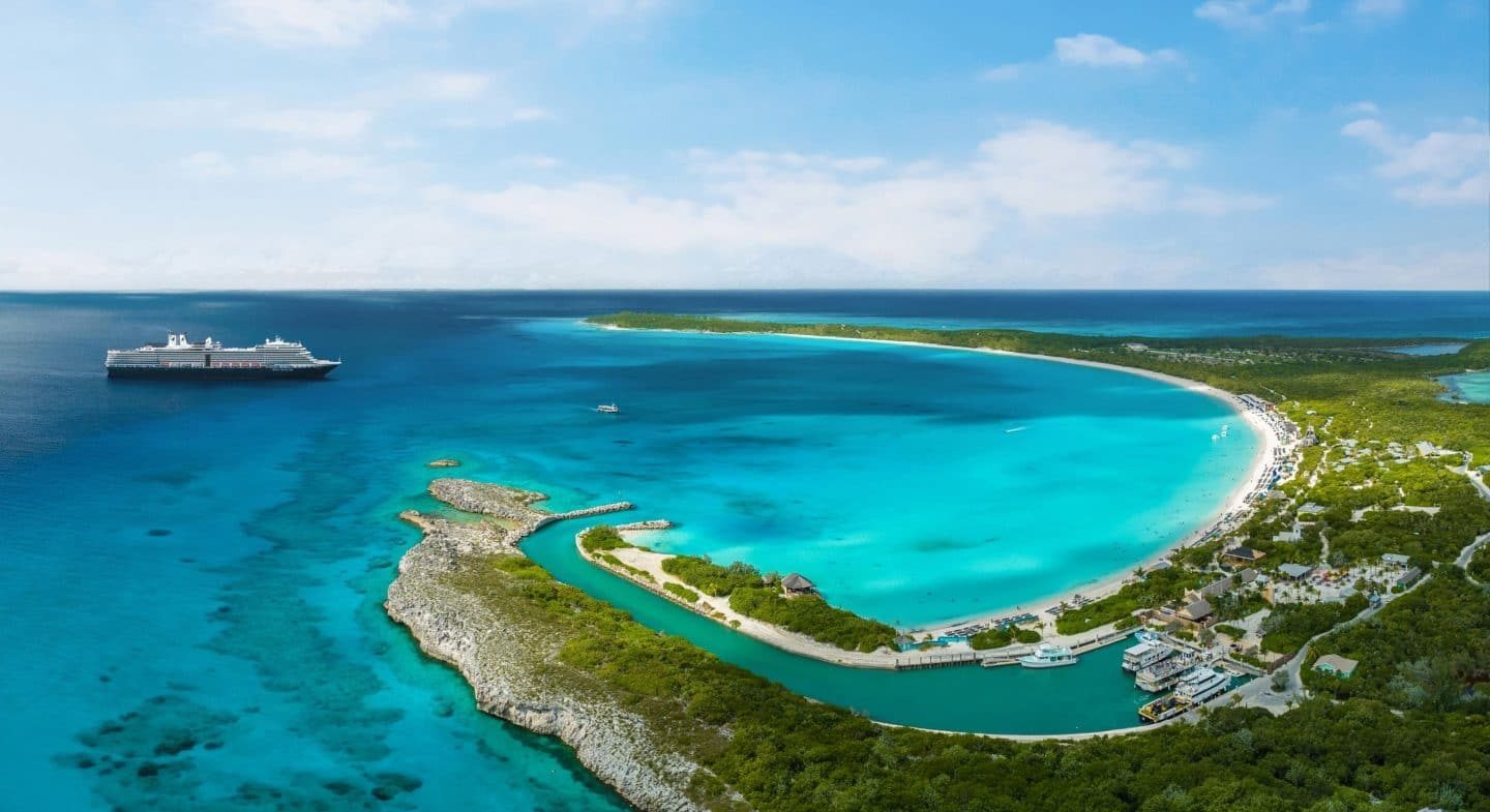 Aerial view of Half Moon Cay's crescent beach and lagoon with a Holland America Line ship anchored offshore