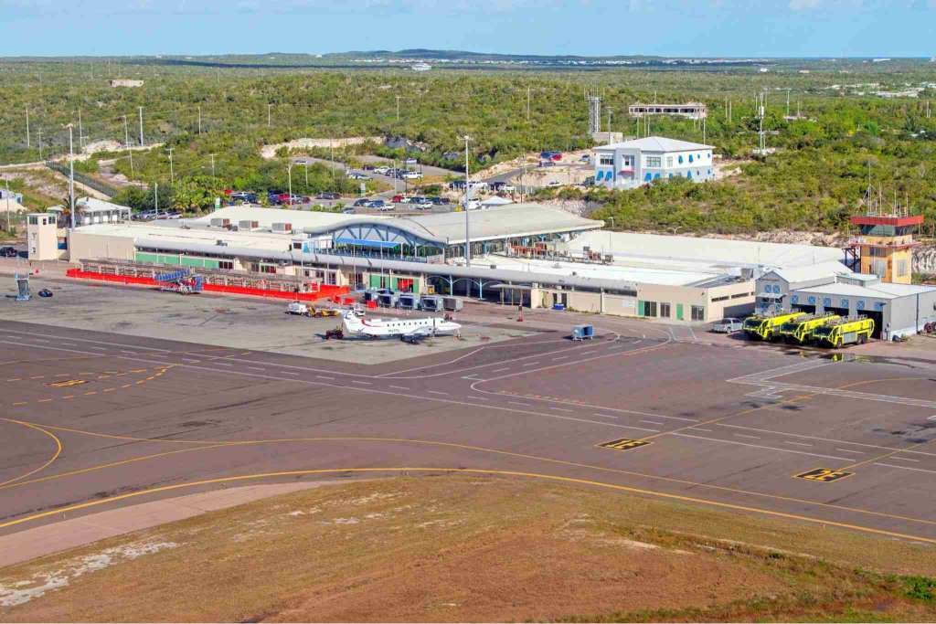 Aerial view of Providenciales International Airport in Turks and Caicos, with the terminal, ramp and a small turboprop aircraft